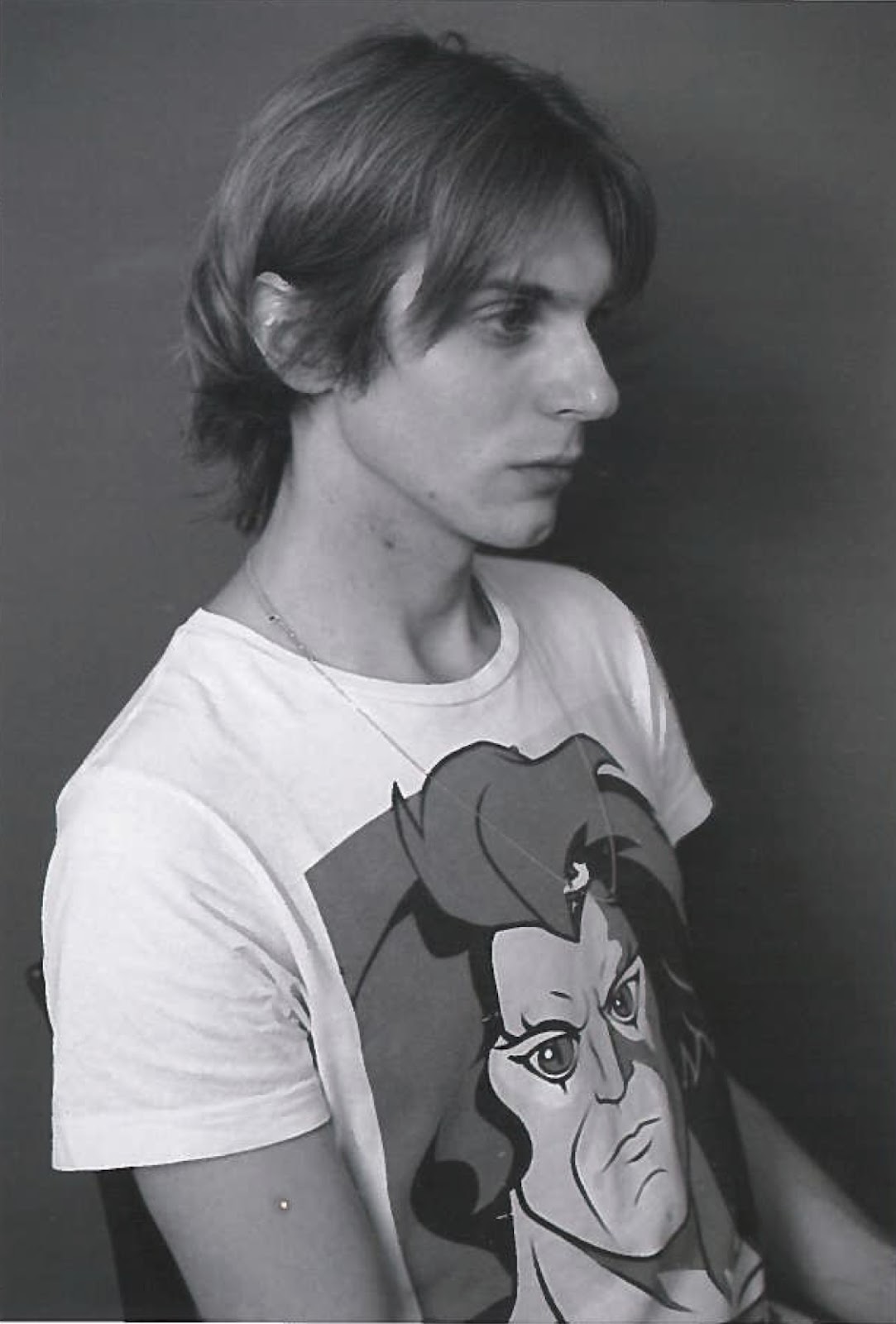 Schwarzweiß Portrait von Egon Thuile. Er trägt ein weißes T-Shirt mit Comic-Aufdruck und schaut melancholisch zur Seite.