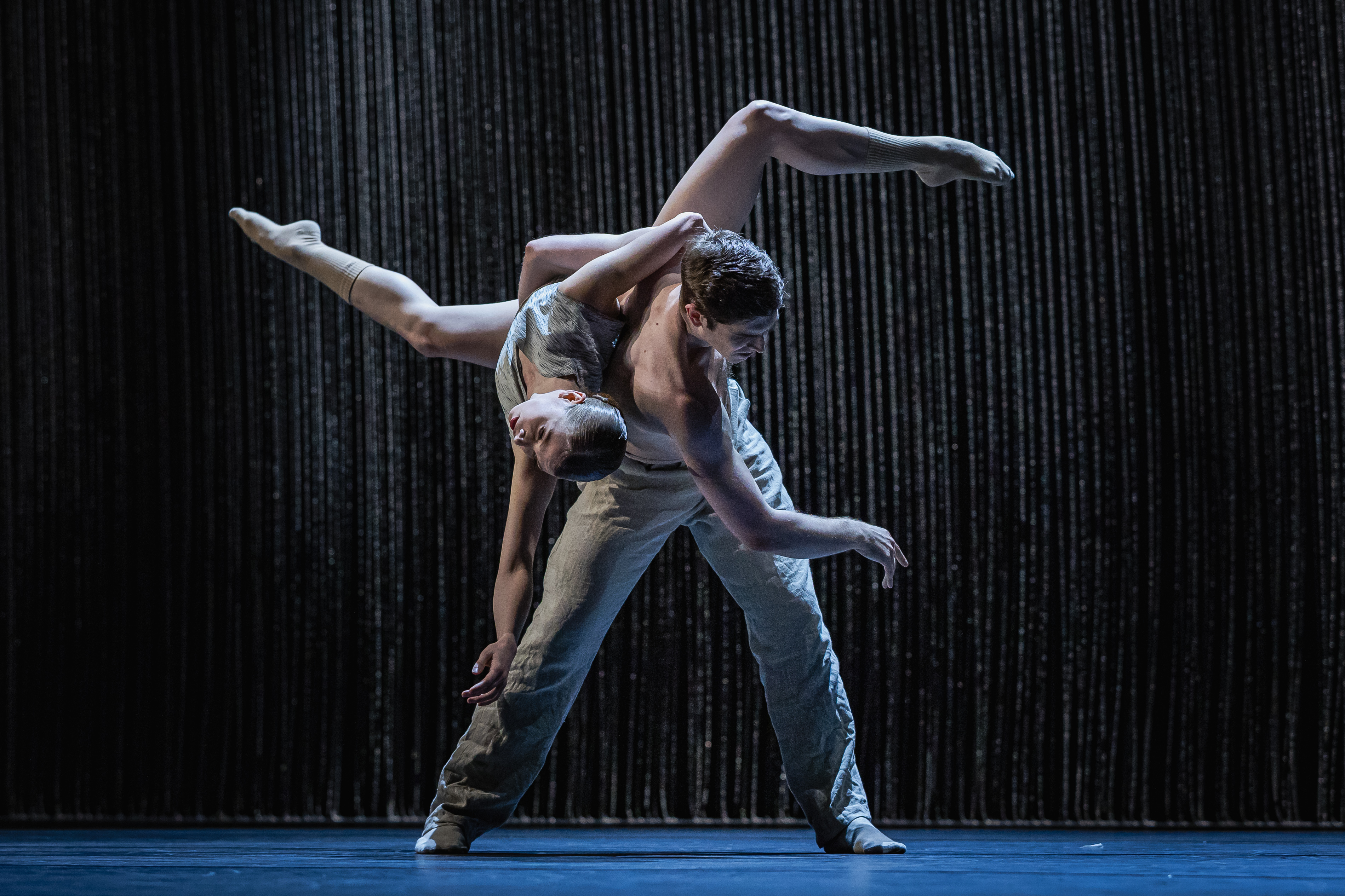 Michelle Willems und Matthew Knight tanzen vor einem Vorhang aus Metallketten.