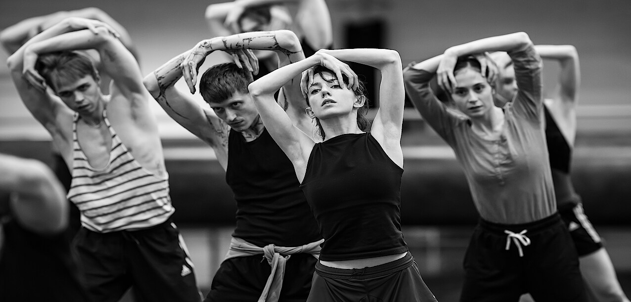 Tänzer*innen verschränken die Arme über dem Kopf bei Proben zu Overture im Ballettsaal.
