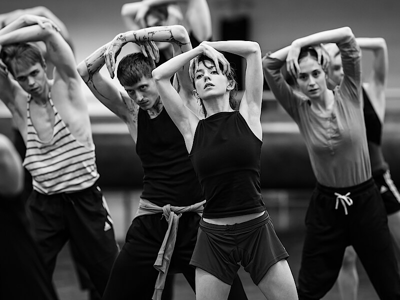 Tänzer*innen verschränken die Arme über dem Kopf bei Proben zu Overture im Ballettsaal.