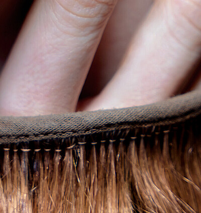 Nahaufnahme zweier Finger, die aus einem Haarkostüm herausragen.
