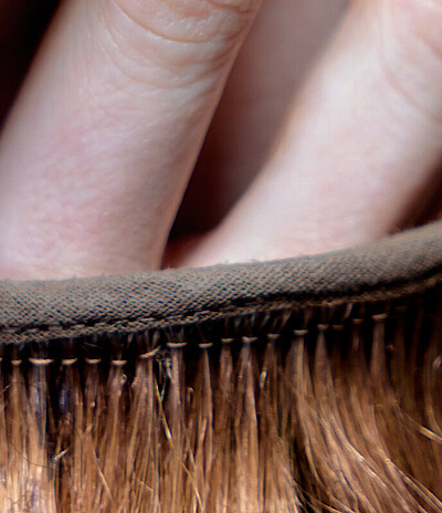 Nahaufnahme zweier Finger, die aus einem Haarkostüm herausragen.