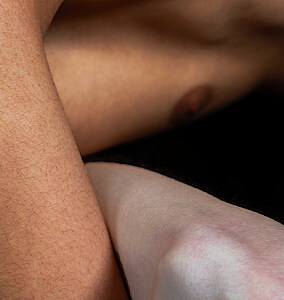 Männlicher Oberkörper vornüber gebeugt, verschlungen mit dem Arm einer anderen Person