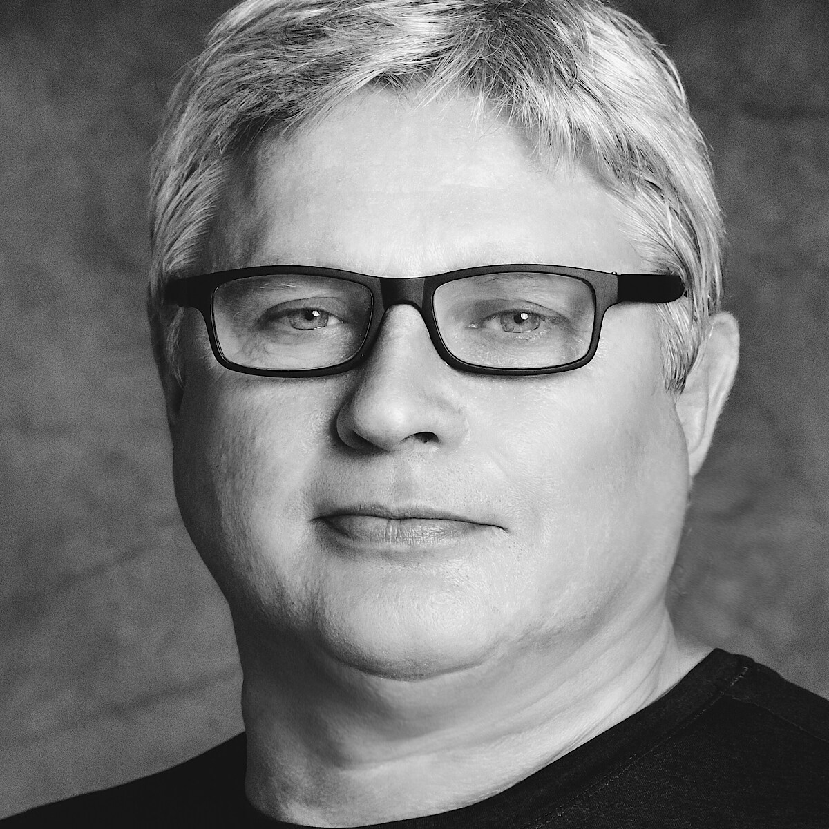 Yuri Possokhov (c) Lindsey Rallo / San Francisco Ballet Schwarz-weiß-Portrait von Yuri Possokhov in schwarzem Shirt und schwarzer Brille.