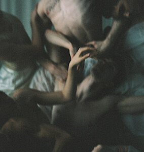 Unscharfe Körper liegen ineinander verschränkt auf dem Boden.