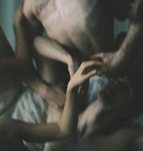 Unscharfe Körper liegen ineinander verschränkt auf dem Boden.