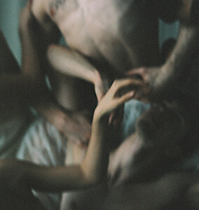 Unscharfe Körper liegen ineinander verschränkt auf dem Boden.