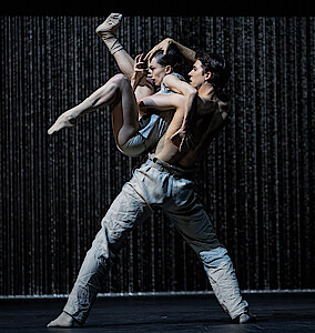 Martin ten Kortenaar und Fiona McGee tanzen vor einem Vorhang aus Metallketten.