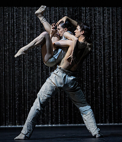 Martin ten Kortenaar und Fiona McGee tanzen vor einem Vorhang aus Metallketten.