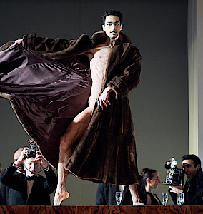 Tänzer in Mantel und Fotografen