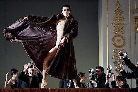 Tänzer in Mantel und Fotografen