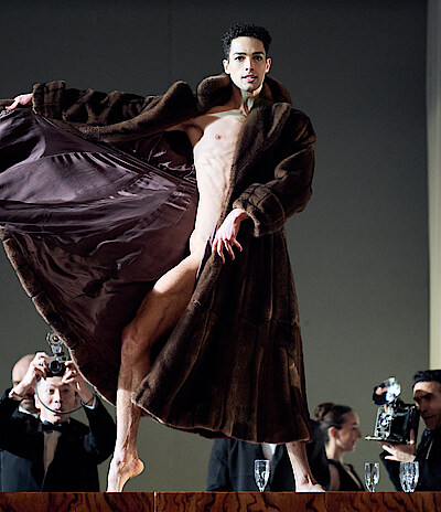 Tänzer in Mantel und Fotografen