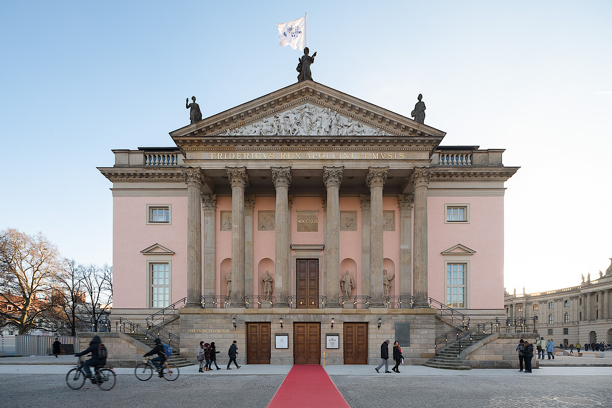 Vorderansicht der Staatsoper Unter dem Linden vor blauem Himmel.