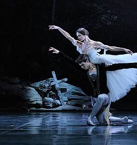 Giselle Polina Semionova als Giselle über dem knienden Martin ten Kortenaar als Albrecht gebeugt.