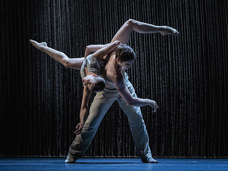 2 dancers before black background