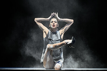 Polina Semionova, sitzend, in Staub gehüllt, blickt dramatisch in Richtung Kamera, in Sol Leons "Stars Like Moths"
