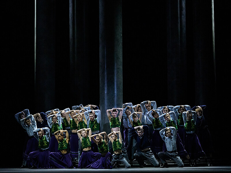 Ensemble tanzt um eine schwarze Säule.